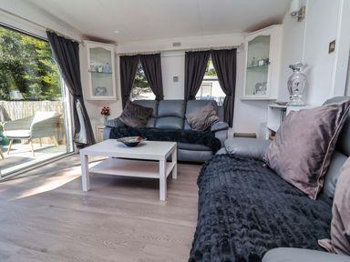 A living room with a sofa and table at Grosvenor 10 Llanarmon-Yn-Ial