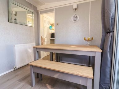 A dining room with a table and bench at Grosvenor 10 Llanarmon-Yn-Ial