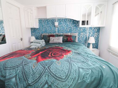 A bedroom with a bed, pillows, and decorative wall at Grosvenor 10 in Llanarmon-Yn-Ial