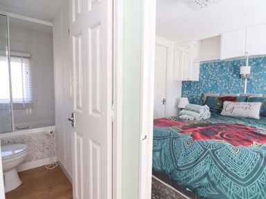 A bedroom with a bed and attached bathroom at Grosvenor 10 Llanarmon-Yn-Ial