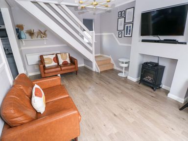 A living room with a sofa and television at The Wool Pack in Tenby