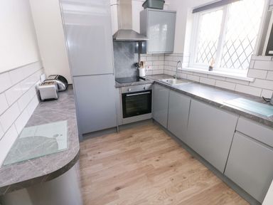 A kitchen with a sink and oven at The Wool Pack in Tenby