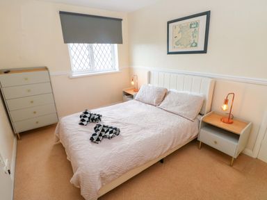 A bedroom with a bed and drawers at The Wool Pack in Tenby
