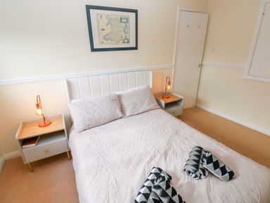 A bedroom with a bed and nightstand at The Wool Pack in Tenby