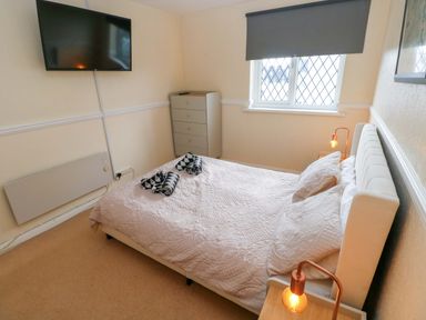 A bedroom with a bed and television at The Wool Pack in Tenby