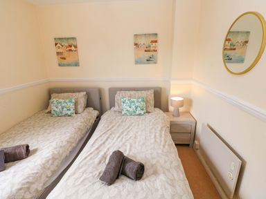 A bedroom with two single beds and a nightstand at The Wool Pack in Tenby