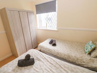 A bedroom with two beds and a wardrobe at The Wool Pack in Tenby