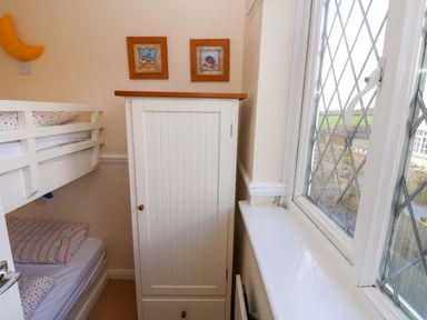 A bedroom with a bunk bed and wardrobe at The Wool Pack in Tenby