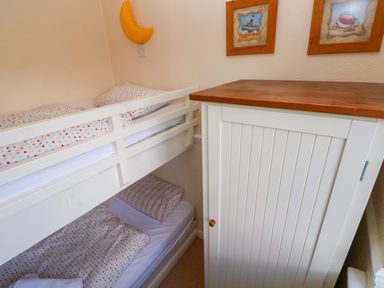 A bedroom with a bunk bed and a wardrobe at The Wool Pack in Tenby