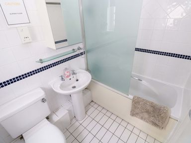 A bathroom with a toilet, sink, and bathtub at The Wool Pack in Tenby