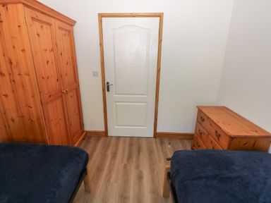 A bedroom with a wardrobe and a drawer at Brookview Kingfisher Haverfordwest