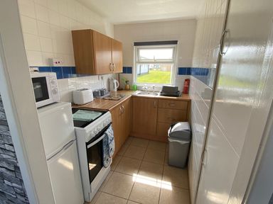 A kitchen with appliances and a window at Chalet 57 California, Norfolk