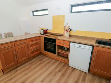 A kitchen with wooden cabinets and appliances at Brookview Goldfinch in Haverfordwest