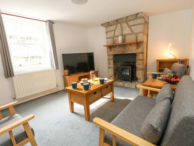 A living room with a sofa and television at NO 10 in Fortuneswell