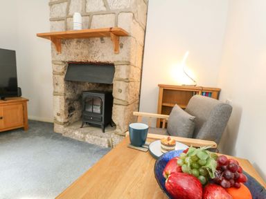 A living room with a fireplace and wooden furniture at NO 10 Fortuneswell
