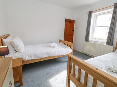 A bedroom with two beds and a window at NO 10 Fortuneswell