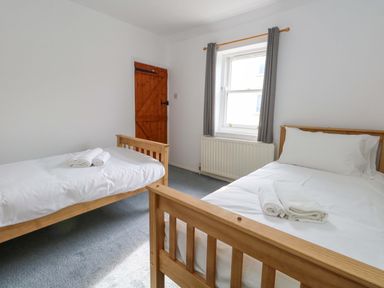 A bedroom with two beds and a window at NO 10 Fortuneswell