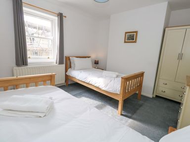 A bedroom with two beds and a wardrobe at NO 10 in Fortuneswell