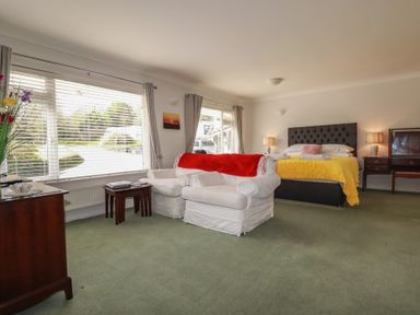 A bedroom with a bed and armchair at Tregoning annex in Lerryn near Lostwithiel