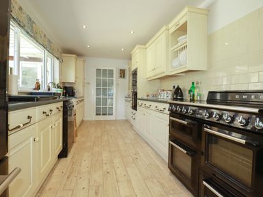 A kitchen with cabinets, sink, and oven at Tregoning in Lostwithiel