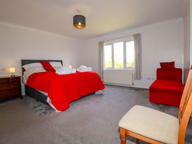A bedroom with a bed and chair at Tregoning in Lostwithiel