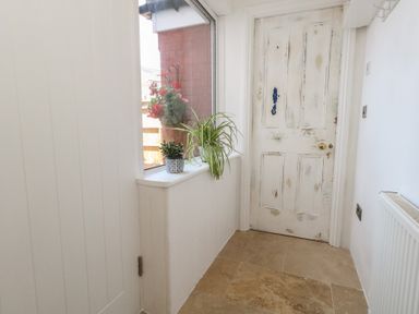 A hallway with a door and a window at Tipsy Turtle in Weymouth