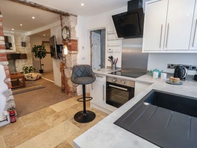 A kitchen with modern appliances and a seating area at Tipsy Turtle in Weymouth