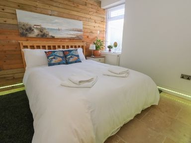 A bedroom with a bed and bedside table at Tipsy Turtle in Weymouth