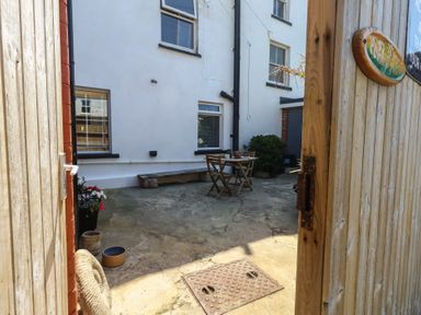 An outdoor patio with a table and chairs at Tipsy Turtle in Weymouth