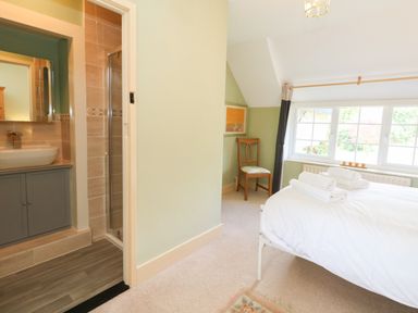 A bedroom with a bed and bathroom area at Rose Cottage in Osmington