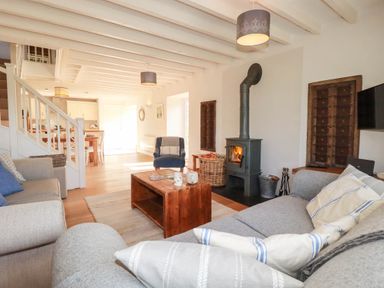 A living room with a fireplace and a coffee table at Bryher Cottage in St Mawgan