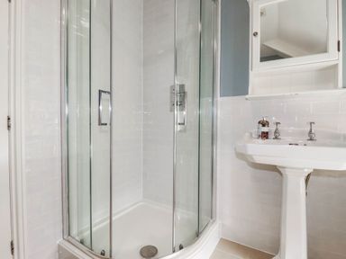 A bathroom with a shower and sink at Bryher Cottage St Mawgan
