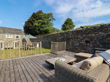 A deck with outdoor furniture at Bryher Cottage in St Mawgan