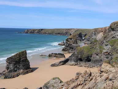 A view of a beach with cliffs and rocks at Bryher Cottage St Mawgan