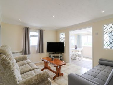 A living room with a sofa and television at Watersmeet - 85 @ Park Avenue Holiday Village, Leysdown-On-Sea, Kent
