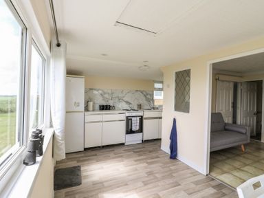A kitchen with countertop and refrigerator at Watersmeet - 85 @ Park Avenue Holiday Village in Leysdown-On-Sea, Kent