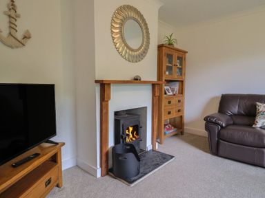 A living room with a television and a fireplace at 2 North Road Maiden Newton, Dorset