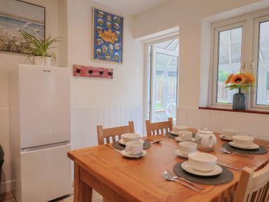 A dining room with a table set for meal at 2 North Road Maiden Newton Dorset