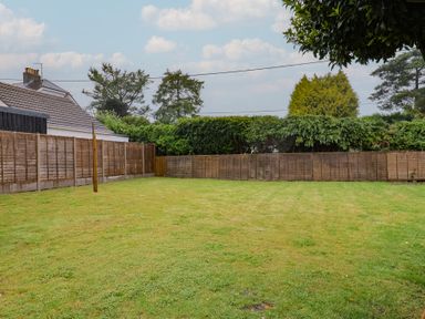 A garden with grass and fences at 2 North Road in Maiden Newton, Dorset