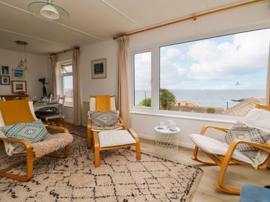 A living room with chairs and a window view at Wootton Gray in Penzance