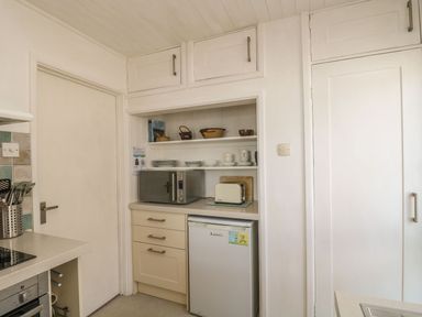 A kitchen with cabinets and appliances at Wootton Gray in Penzance