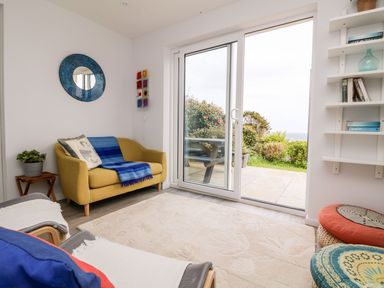 A living room with a sofa and sliding door at Wootton Gray Penzance