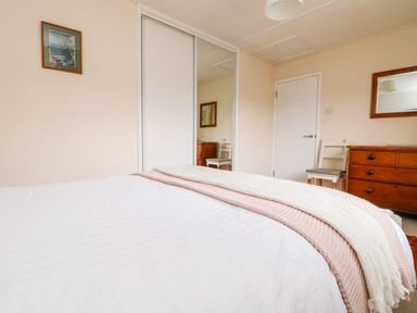 A bedroom with a bed and furniture at Wootton Gray in Penzance