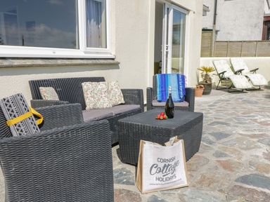 A patio area with outdoor seating and a coffee table at Wootton Gray in Penzance