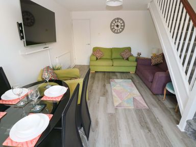 A living room with a sofa and dining area at The Gower Gateway in Gowerton near Swansea
