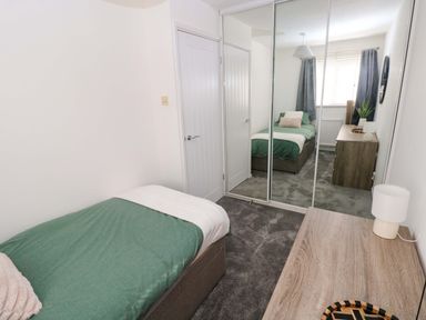 A bedroom with a bed, wardrobe, and desk at The Gower Gateway in Gowerton near Swansea