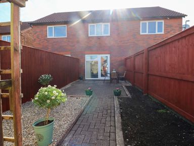 A garden with paved area and flower pots at The Gower Gateway in Gowerton near Swansea