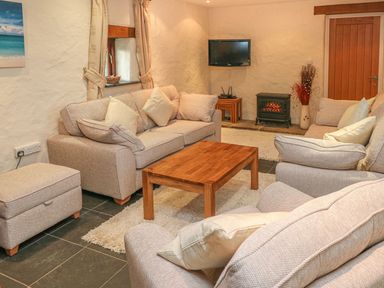 A living room with a sofa coffee table and television at Maerdy Cwtch Haverfordwest