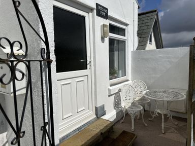 An outdoor area with a table and chairs at Treese Dale Lodge, Hayle