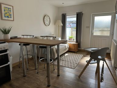 A living room with a sofa and dining table at Dog-friendly lodge, steps to St Ives train, Hayle